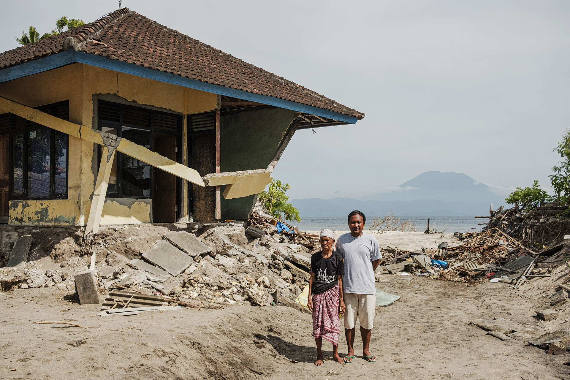 Ketut Sunantri (left) and Wayan Sugita (right) in front of their shattered house